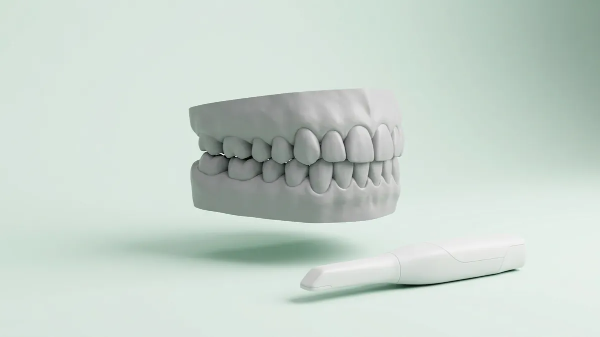 Digitales 3D-Modell von Ober- und Unterkiefer im Biss, daneben ein Intraoralscanner
